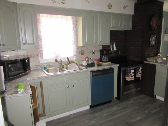 Kitchen with decorative backsplash, a sink, stainless steel range with electric cooktop, dishwasher, and wood finished floors