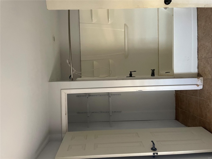 Bathroom with tile patterned flooring and shower / washtub combination