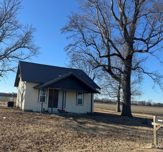View of front of home with metal roof and a rural view