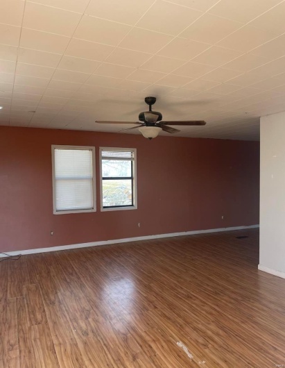Empty room featuring baseboards, wood finished floors, and ceiling fan
