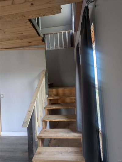 Stairway featuring baseboards and wood finished floors