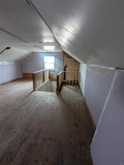Additional living space featuring lofted ceiling and wood-type flooring