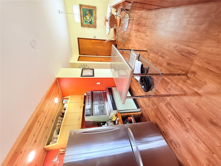 Kitchen with wall oven, light wood-style floors, and fridge