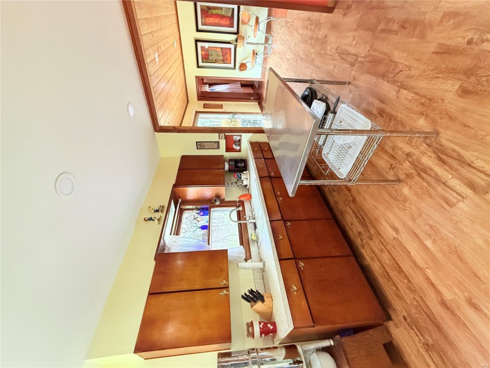 Kitchen featuring light countertops, a sink, brown cabinetry, and light wood-style floors