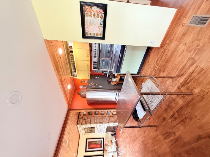 Kitchen featuring light wood-style flooring, visible vents, wall oven, wood ceiling, and freestanding refrigerator