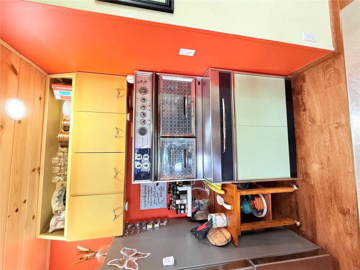 Kitchen featuring baseboards, light wood-style flooring, refrigerator, and wooden ceiling