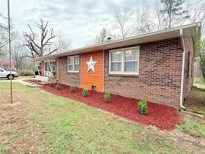 Ranch-style home featuring a front lawn and brick siding