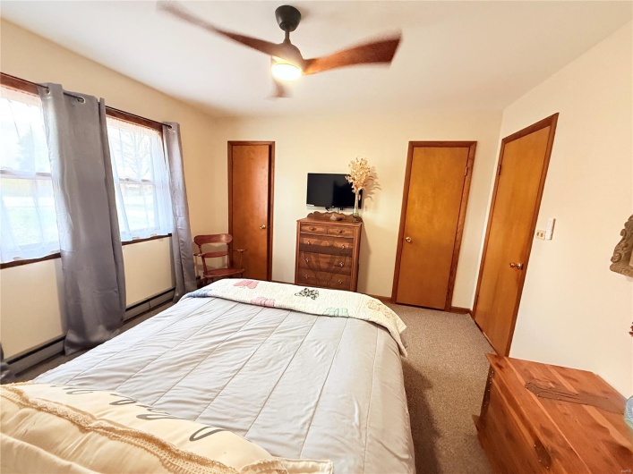 Bedroom featuring multiple closets, carpet floors, and a ceiling fan