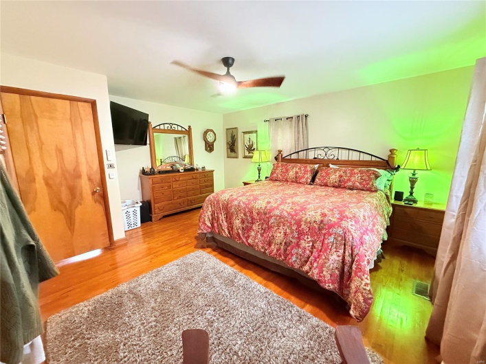 Bedroom featuring visible vents, wood finished floors, and a ceiling fan