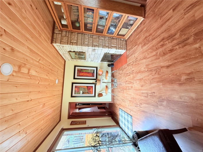 Unfurnished room with crown molding, wooden ceiling, baseboards, a stone fireplace, and wood finished floors