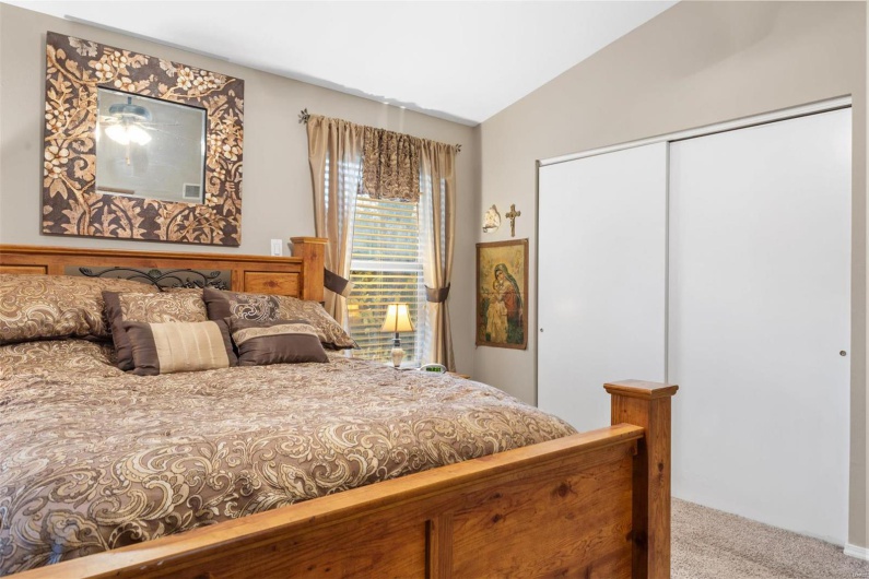 Carpeted bedroom with lofted ceiling and a closet