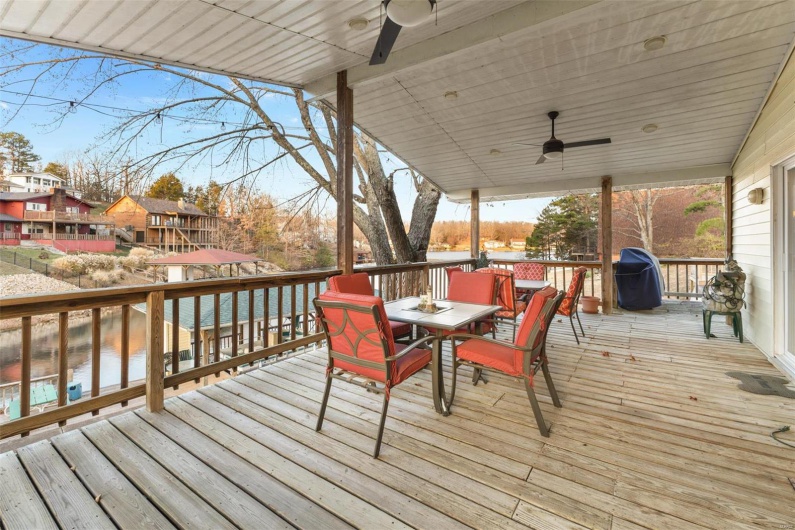 Wooden terrace featuring a water view and ceiling fan