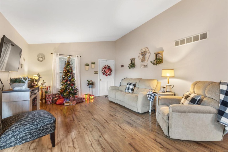 Living room with light wood-type flooring and lofted ceiling