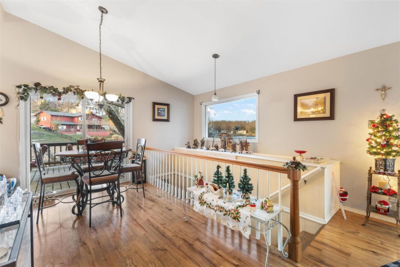 Dining area with a chandelier, hardwood / wood-style flooring, and lofted ceiling