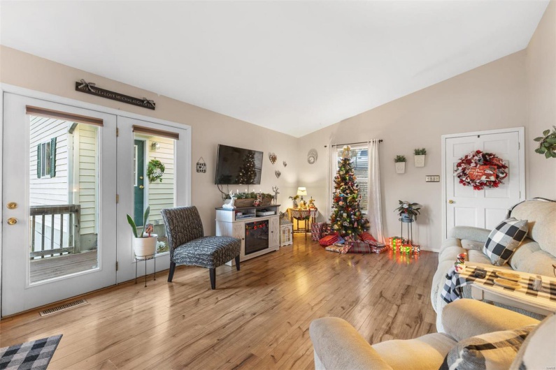 Living room with vaulted ceiling and light wood-type flooring