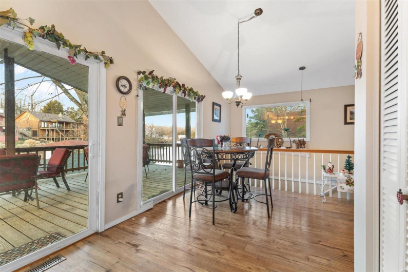 Dining room featuring hardwood / wood-style floors, an inviting chandelier, and lofted ceiling