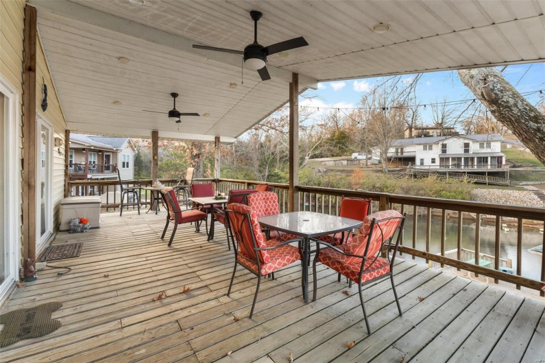Wooden terrace with ceiling fan and a water view