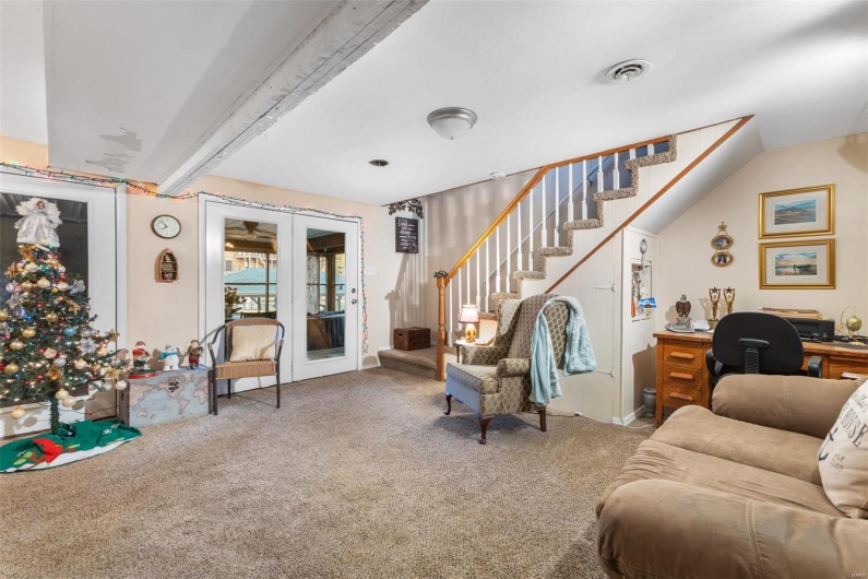 Living room with carpet, french doors, and vaulted ceiling with beams