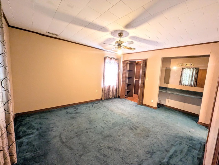 Unfurnished bedroom featuring baseboards, crown molding, carpet flooring, and visible vents