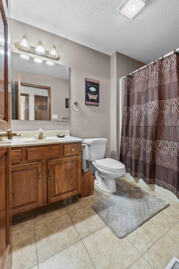 Bathroom featuring visible vents, toilet, a textured ceiling, vanity, and tile patterned flooring