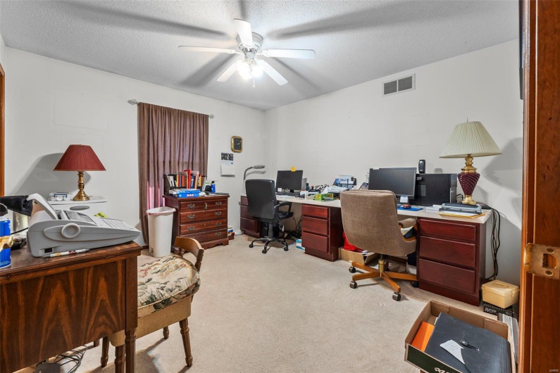 Office featuring visible vents, a ceiling fan, light colored carpet, and a textured ceiling