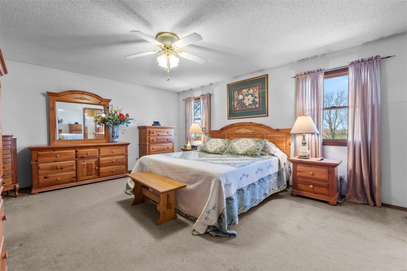 Bedroom featuring carpet flooring, a textured ceiling, and ceiling fan