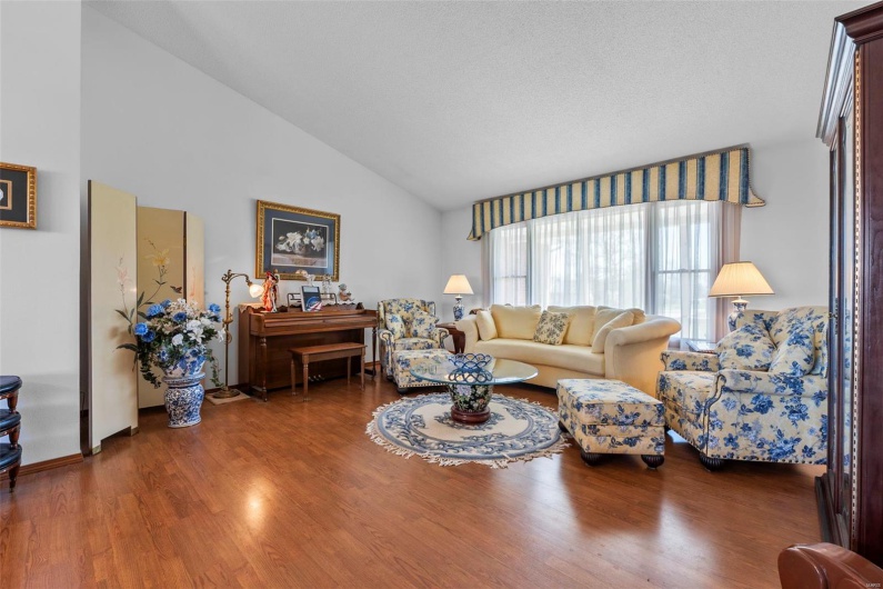 Living room featuring vaulted ceiling and wood finished floors