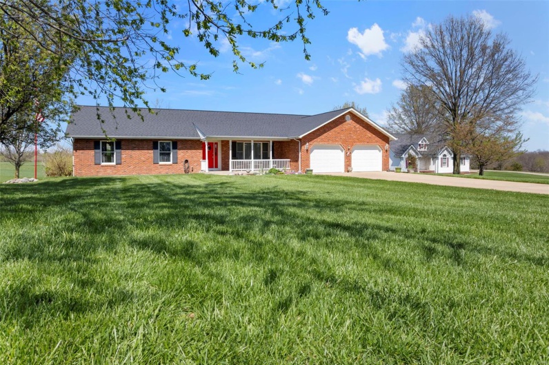 Single story home with a garage, a front yard, driveway, and brick siding
