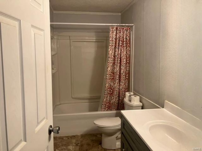 Full bathroom with ornamental molding, shower / bath combo, vanity, and toilet