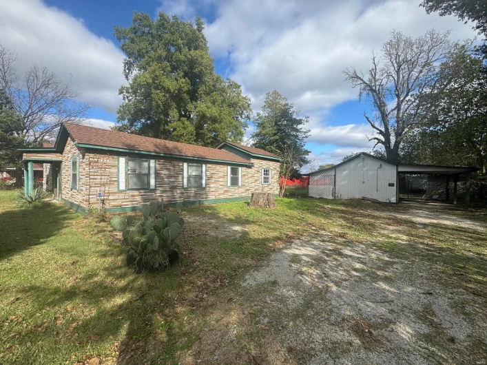 View of home's exterior featuring a carport and a yard