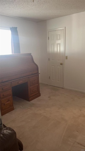 Office area with light carpet, a textured ceiling, and baseboards
