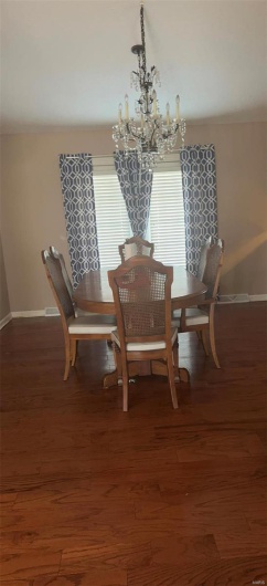 Dining area with an inviting chandelier, baseboards, and wood finished floors