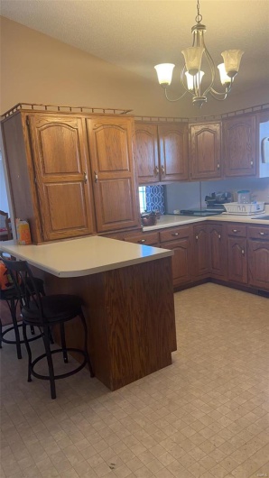Kitchen featuring a chandelier, light countertops, light floors, and decorative light fixtures