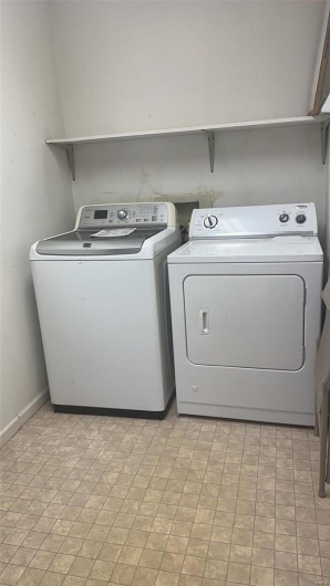 Washroom with laundry area, washing machine and dryer, and baseboards