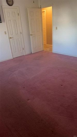 Carpeted spare room featuring baseboards