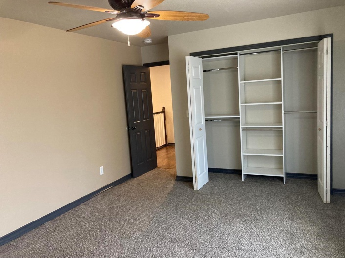 Unfurnished bedroom featuring carpet, a ceiling fan, baseboards, and a closet