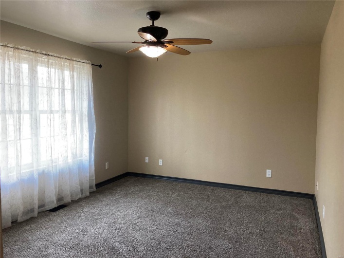 Spare room with carpet, a ceiling fan, and baseboards