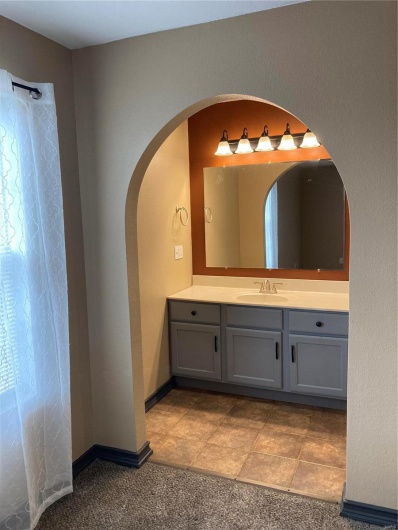 Bathroom featuring vanity, a shower with shower curtain, and baseboards