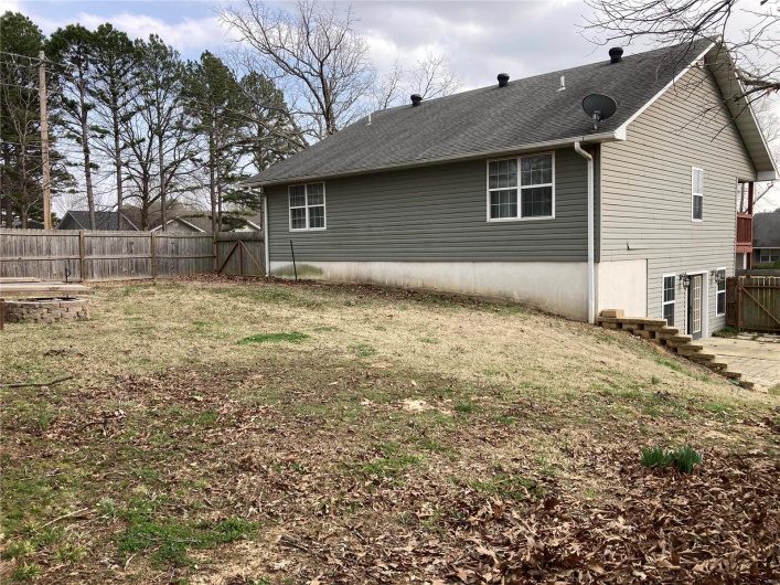 Back of property featuring a yard and fence