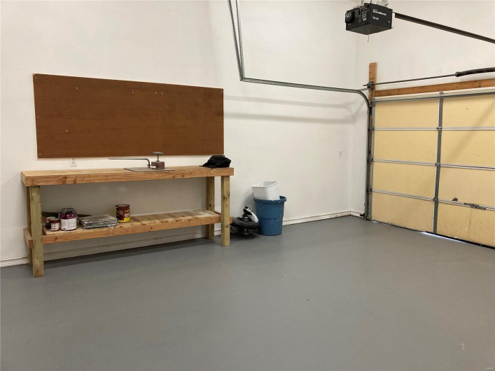 Garage with baseboards and a garage door opener