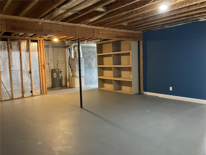 Unfinished below grade area featuring water heater