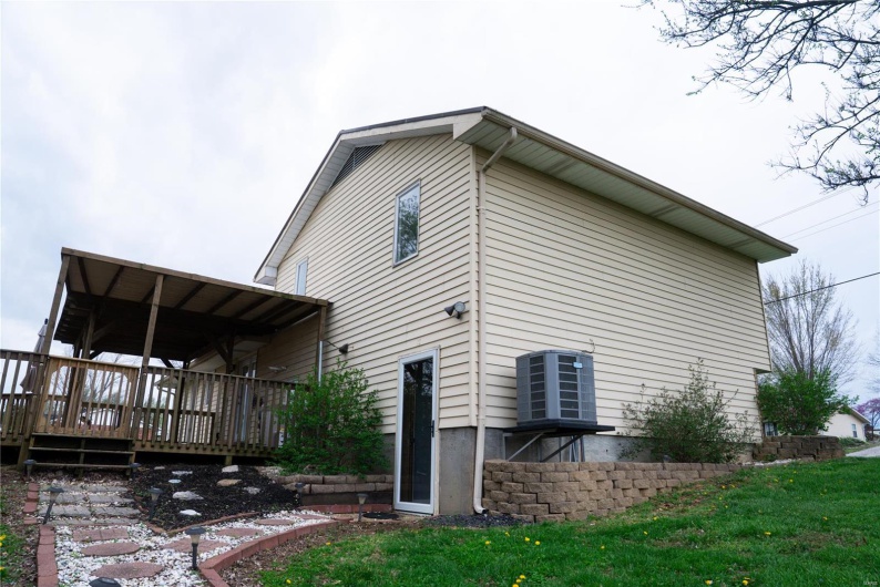 View of property exterior featuring a wooden deck
