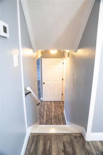 Stairway with visible vents, baseboards, wood finished floors, and a textured ceiling