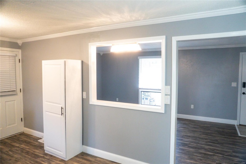 Unfurnished room with ornamental molding, baseboards, and dark wood finished floors
