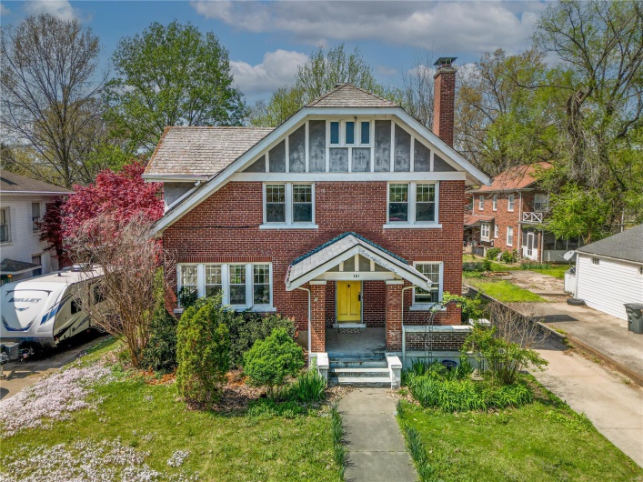 View of front facade featuring brick siding and a chimney