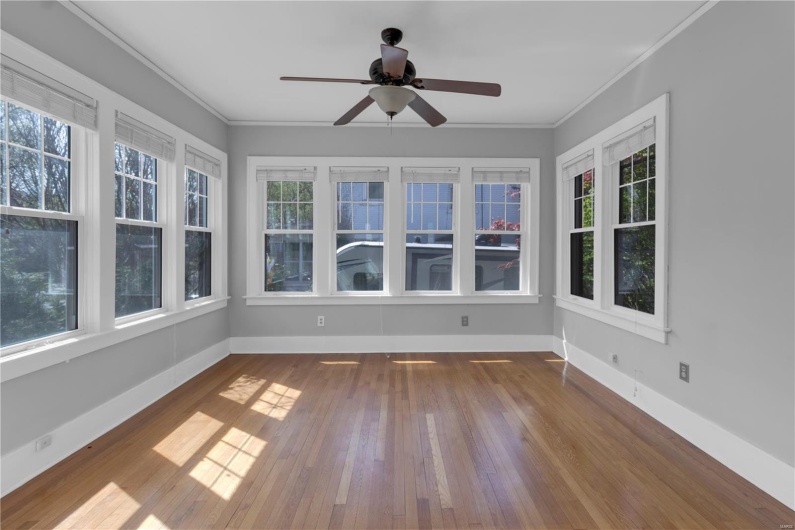 Unfurnished sunroom with hardwood / wood-style floors and a healthy amount of sunlight