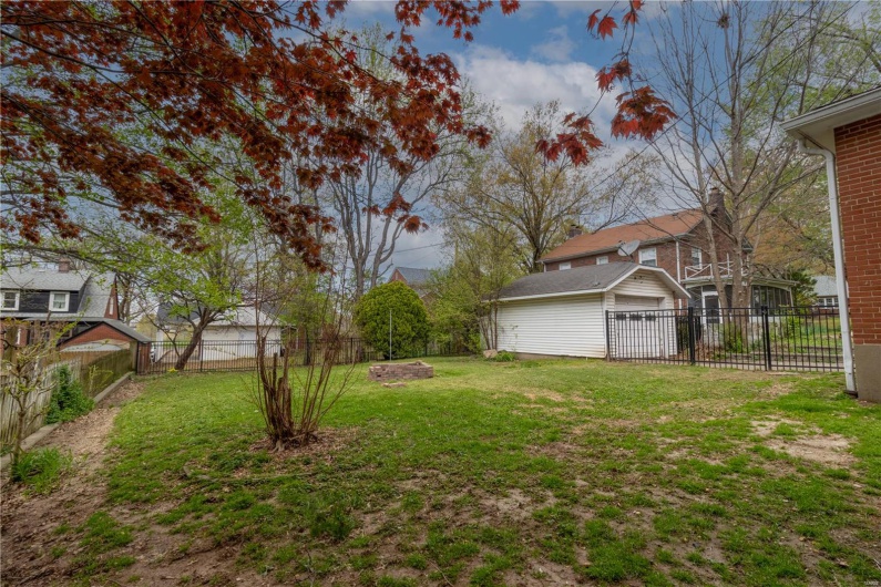 View of yard with a fenced backyard, an outdoor structure, and a garage