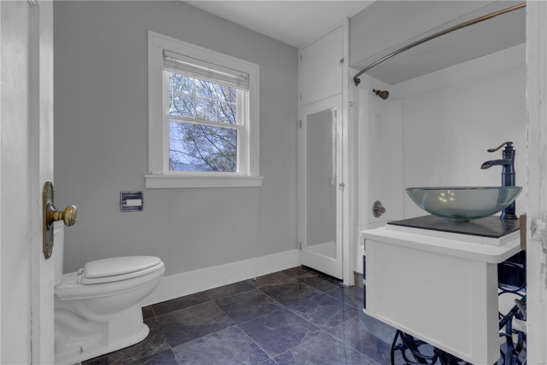 Full bath with vanity, baseboards, walk in shower, and toilet