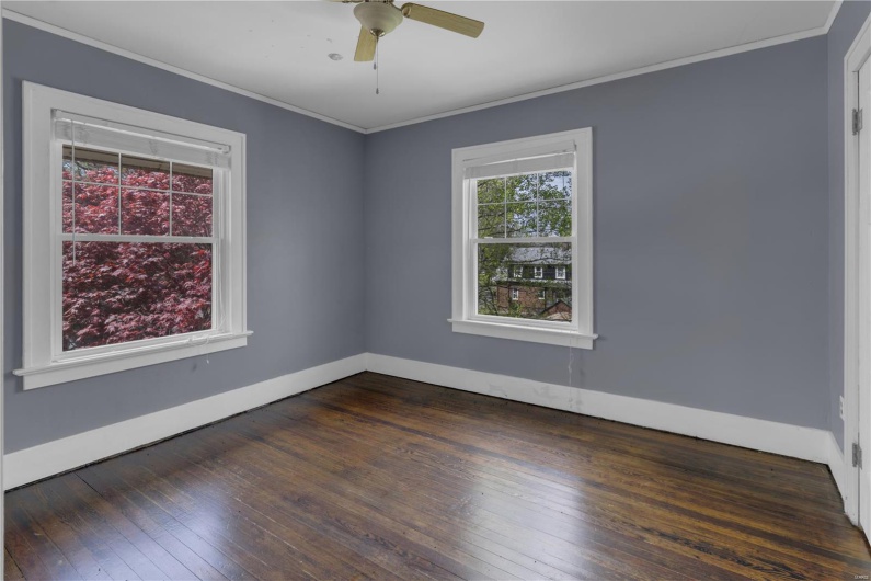 Empty room with crown molding, baseboards, and dark wood-style floors
