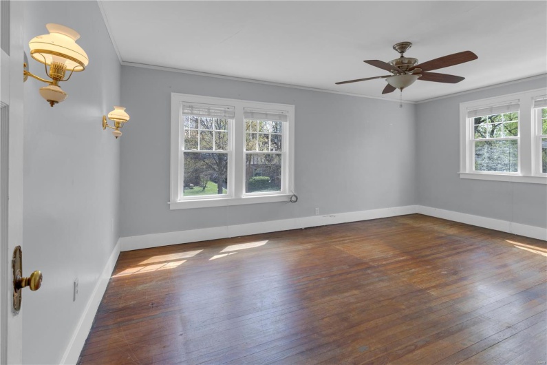 Spare room featuring hardwood / wood-style floors, ceiling fan, baseboards, and ornamental molding